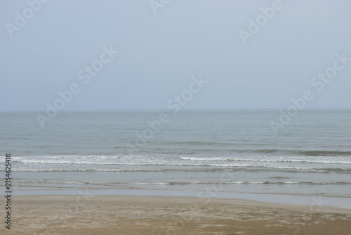 Calm Ban Krut Beach at Low Tide Under Overcast Monsoon Sky in Thailand