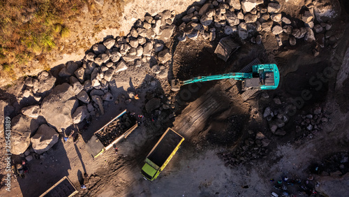 Cuadro en lienzo Aerial view of an excavator loading rocks into a dump truck at a mining quarry w
