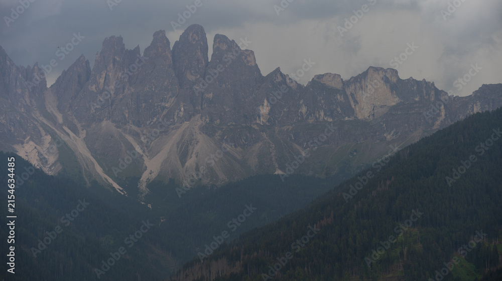 Obraz premium Majestic scenery of rough mountain ridge near grassy hills 