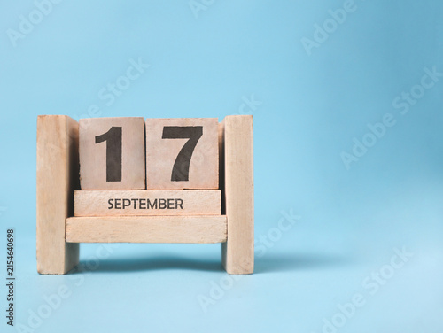 Fotografie A wooden block calendar for September 17th on a light blue background
