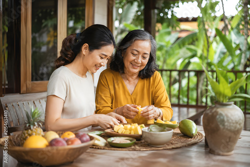 Mother and daughter preparing fresh fruit