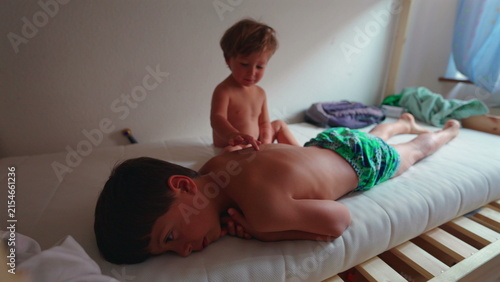 Obraz na płótnie Young siblings relax together on a bedroom mattress at home, sharing a calm ever