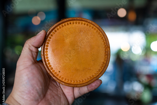 Hand holding a round dough, ready to eat
