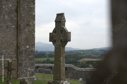Ancient Celtic cross standing tall amidst Irish landscape, symbolizing enduring faith and cultural heritage for travel and education purposes, inviting exploration and discovery of historical landmark