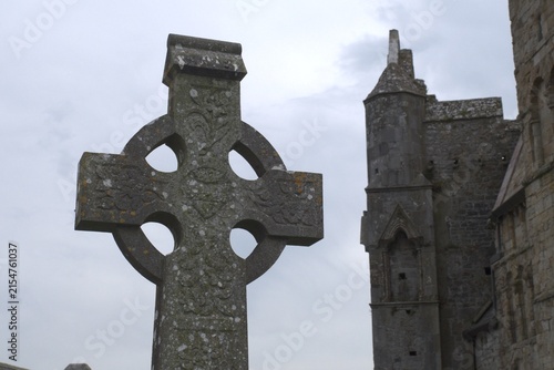 Exploring ancient celtic cross and medieval ruins of Rock of Cashel in Ireland, uncovering historical significance and cultural heritage for travel and documentary projects