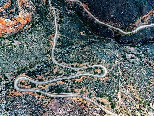 Aerial of mountain pass, dirt road winding from above