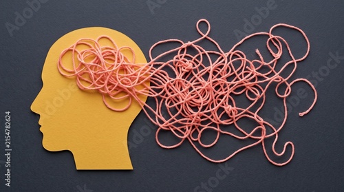 A profile of a head showing a cluttered mind as jumbled text made of pink yarn for mental health awareness.