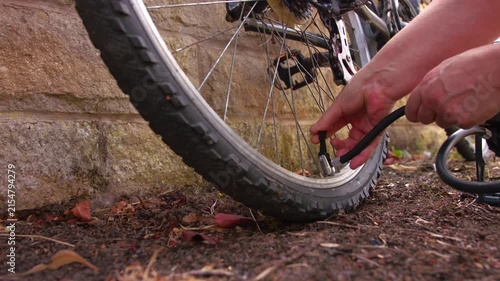 Cyclist pumping flat tyre on bicycle