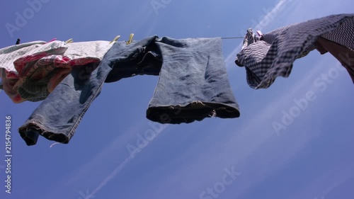 Laundry hangs on the washing line on clear blue sky day
