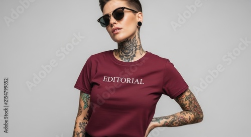 Young woman with tattoos and sunglasses wearing a t-shirt with the word editorial.