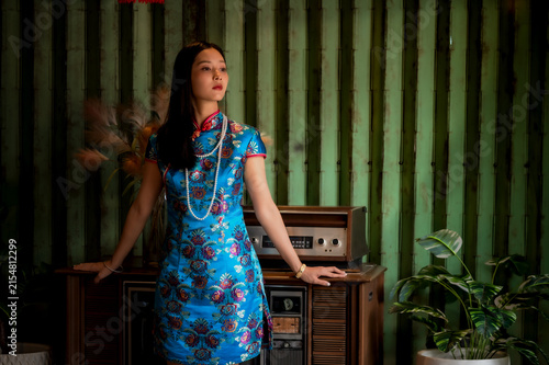 Photography Beautiful young Chinese woman wearing a vibrant silk qipao and vintage pearl nec