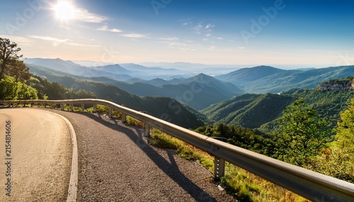 scenic mountain road overlook with guardrail and distant valley view