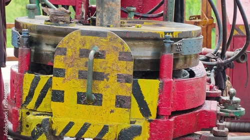Operating power tong, torque machinery, to make connection of the drill pipe in the oil drilling operation. Heavy industrial working scene footage. close-up.