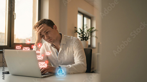 Stressed man overwhelmed by email notifications on laptop, feeling burnout and pressure, with digital alerts flying out of screen
