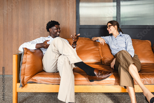 Colleagues Share a Conversation on a Couch in a Casual Setting