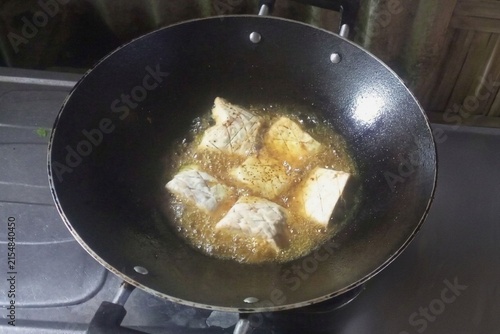 Konstfotografi Fried tempeh pieces sizzle in a black wok