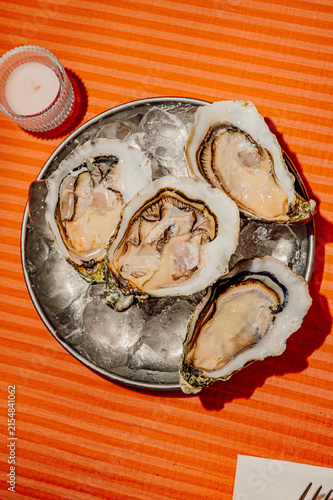 Fresh raw oysters on ice served on a metal platter