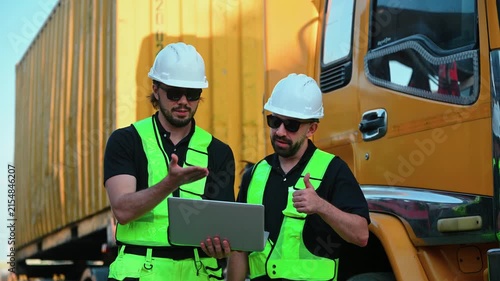 Logistics engineer beside a freight truck, managing cargo transport, supply chain operations, shipping and import-export logistics, supporting equipment inspection, maintenance and utility operations.