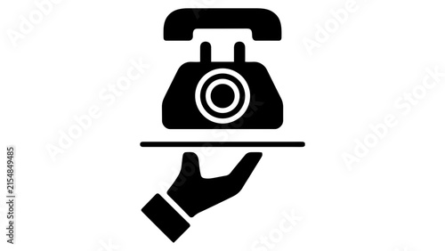 Foto Black silhouette of a hand holding a tray with a vintage rotary telephone on a w