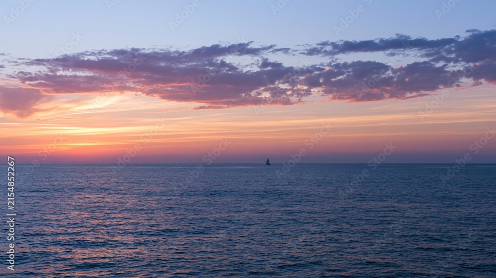Fototapeta premium The Sailboat on a Tranquil Sunset Ocean Horizon with Soft Clouds
