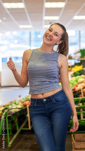 Woman in striped shirt holding smartphone outdoors.