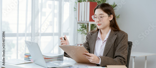 Картината върху платно Businesswoman working with laptop and clipboard