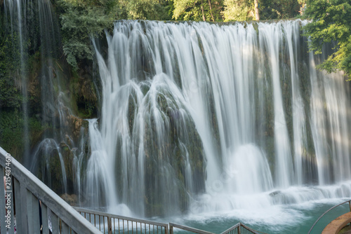 Pliva Waterfall in Jajce, Bosnia and Herzegovina surrounded by lush green forest