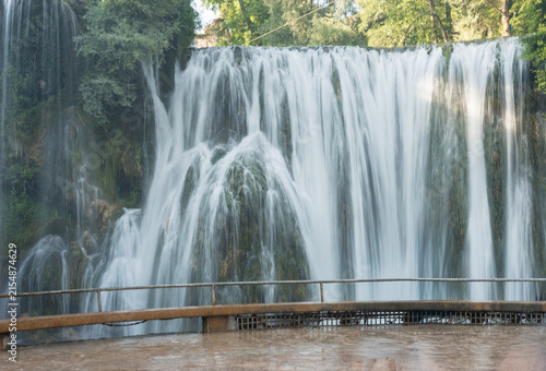 Pliva Waterfall in Jajce, Bosnia and Herzegovina surrounded by lush green forest