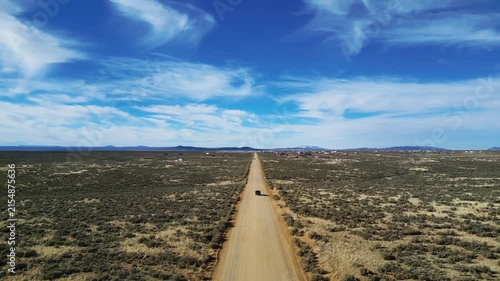 Car driving on dirt road in the desert 