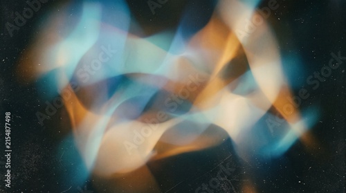 Abstract flowing blue and orange light trails creating a dynamic and ethereal pattern against a dark, textured background.