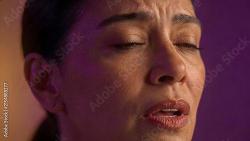 Woman with closed eyes expressing deep concentration in warm lighting  