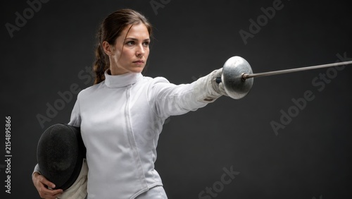 Female Fencer Holding Mask and Pointing Foil Sword. Concept of fencing, epee.