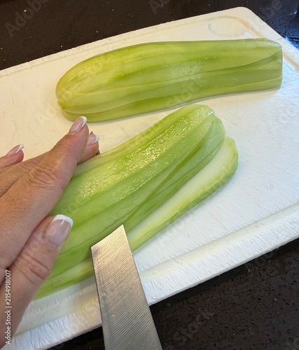Sliced zucchini on cutting board with knife