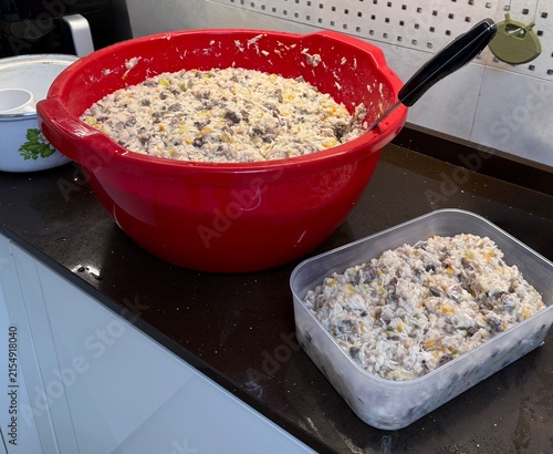 Large bowl of mixed ingredients on kitchen counter with container  