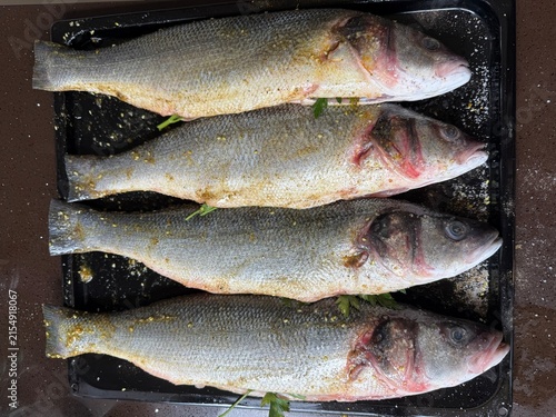 Fresh fish on a tray seasoned and ready for cooking  