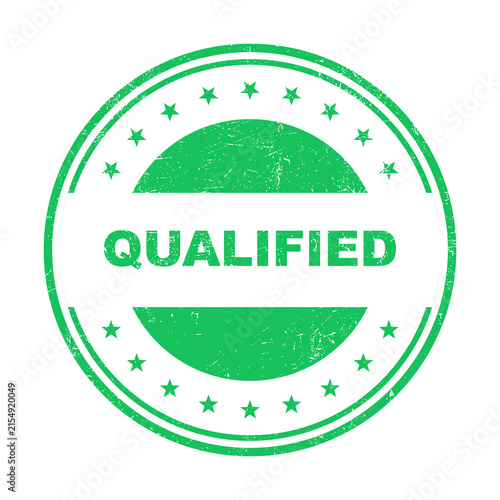 Fotografie Green circular rubber stamp with the word qualified inside in a grunge style iso