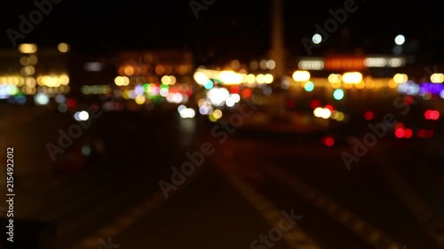 Nighttime scene of a city street with blurred traffic and lights