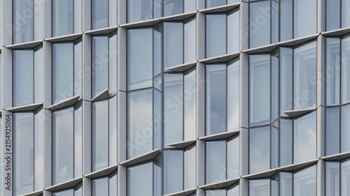 Glass facade of modern building reflecting clouds