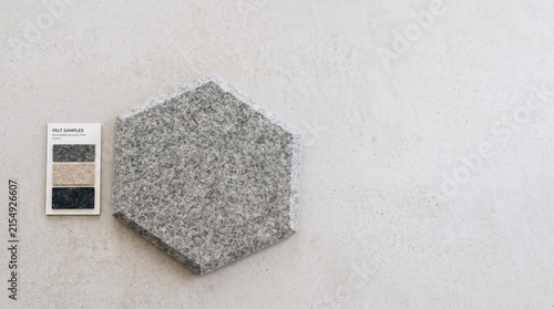 Gray hexagonal tile sample on a textured wall with color swatches  