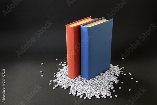 Books with colorful paper covers are lined up against colorful paper backgrounds. School education featuring attractive, bright, and colorful books.