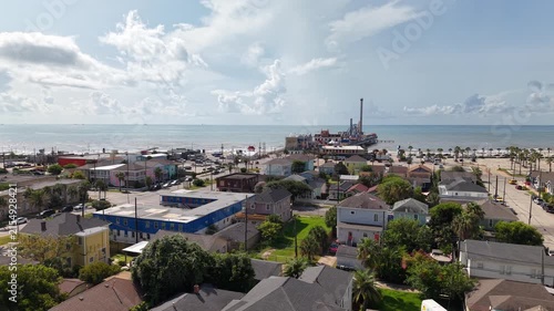 Aerial view of Galveston Island coastal town and Historic Pleasure Pier amusement park on ocean shoreline bright sunny day Texas