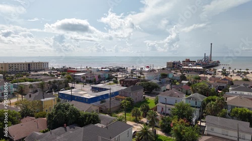 Aerial view of Galveston Island coastal town in Texas and Historic Pleasure Pier amusement park on ocean shoreline on a Sunny Day