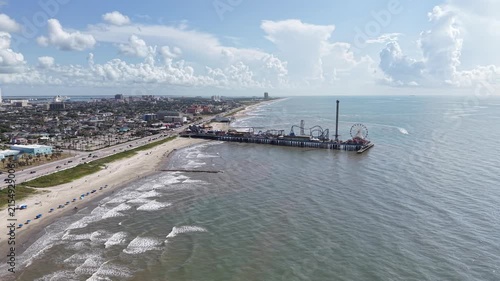 Aerial view of Galveston Island coastal town in Texas and Historic Pleasure Pier amusement park on ocean shoreline on a Sunny Day