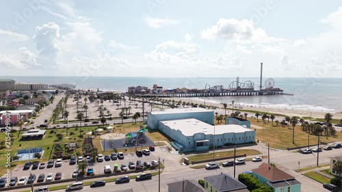 Aerial view of Galveston Island coastal town in Texas and Historic Pleasure Pier amusement park on ocean shoreline on a Sunny Day
