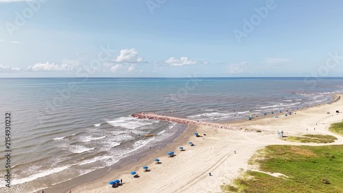 Aerial view of Galveston Island coastal town in Texas and Historic Pleasure Pier amusement park on ocean shoreline on a Sunny Day