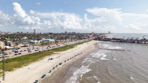 Aerial view of Galveston Island coastal town in Texas and Historic Pleasure Pier amusement park on ocean shoreline on a Sunny Day