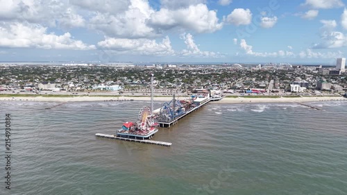 Aerial view of Galveston Island coastal town in Texas and Historic Pleasure Pier amusement park on ocean shoreline on a Sunny Day