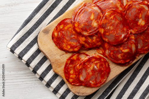 Fotografía Sliced Chorizo Salami on a Wooden Board, top view. Copy space.