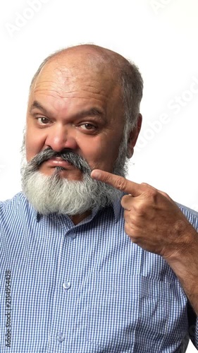 An Indian Asian elderly businessman with a beard is enjoying an apple, highlighting its health benefits gesturing with hands
