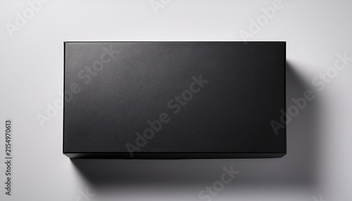 top down view of a closed matte black rectangular box on a white surface with a soft shadow